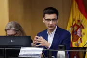 José Pablo López, presidente de RTVE, gesticulando con las manos durante una comparecencia ante la Comisión Mixta de Control Parlamentario, con la bandera de España al fondo